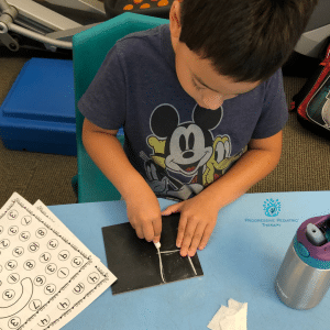 Christian practices forming letter "H" using chalk on a mini chalkboard. 