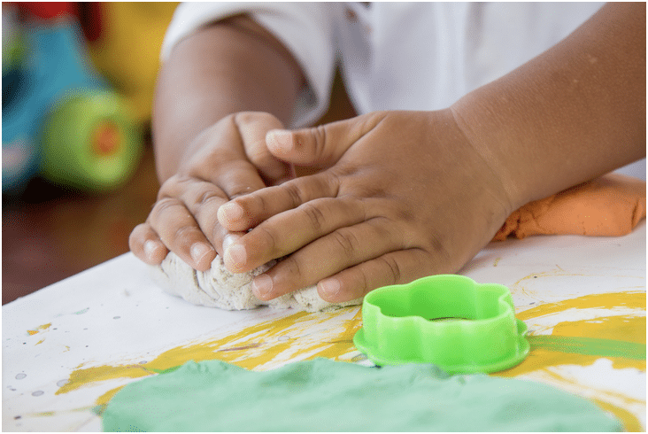 Child's hands molding play doh