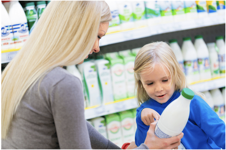 Child pointing to a bottle that her mother is holding