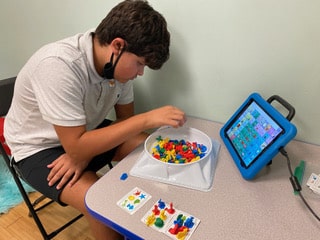 Matthew is working with AAC device in speech therapy