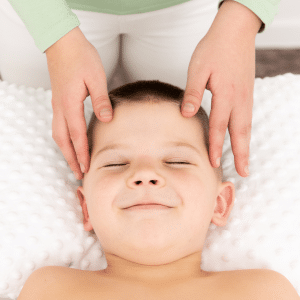 A mom massages a boy's head